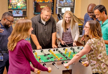 Employees playing foosball in the company game room